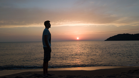silhouette of a man on a sunset background sea coast in summer
