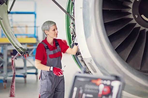 Aircraft mechanic is working in an airplane hangar