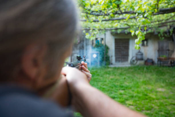 Adult Man Shooting at Target With Airgun on Front Yard.