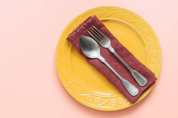 istock Table setting, plate, cutlery and a napkin on a pastel pink background. Top view, flat lay. 1226657833