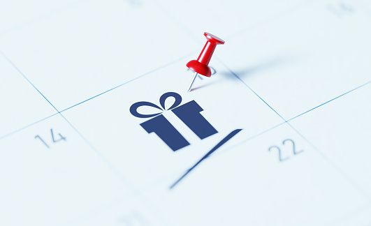 Calendario blanco con pin de empuje rojo para recordar una fecha importante photo