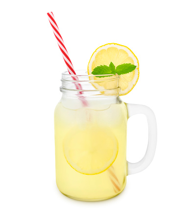 Glass of lemonade with straw and a slice of lemon with mint isolated on white