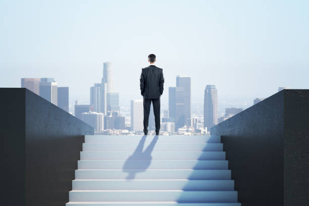 istock Businessman in suit standing on ladder 1226659596