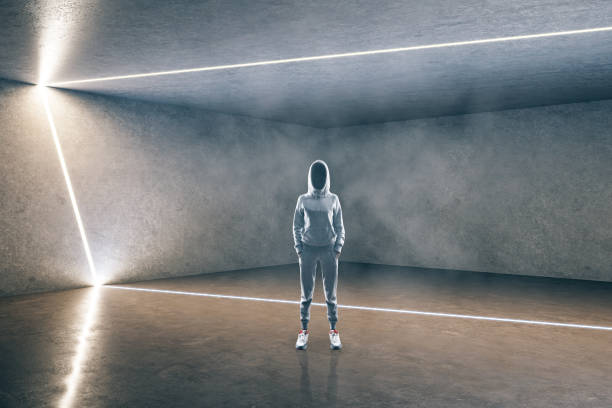 istock Hacker standing in contemporary concrete futuristic gallery interior 1226660431