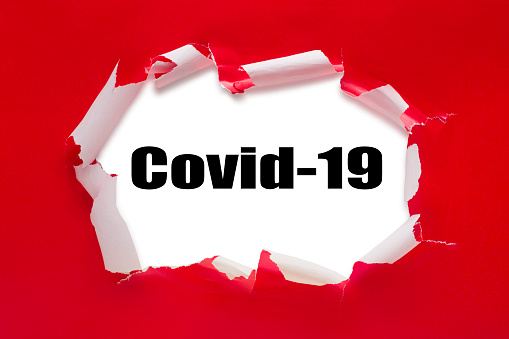 This is a photo of a ripped open red present with the text covid-19 inside