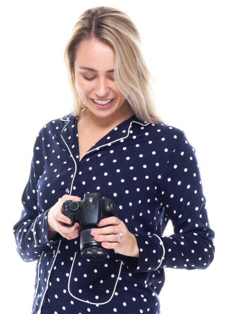 caucasian female photographer standing in front of white background wearing pajamas and holding camera - 7298 imagens e fotografias de stock