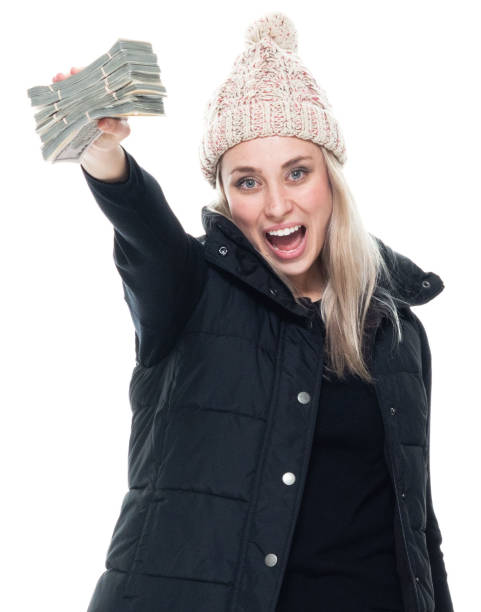 mujer caucásica sin mangas de pie frente al fondo blanco usando ropa de abrigo y sosteniendo la moneda - laughing women us paper currency isolated fotografías e imágenes de stock