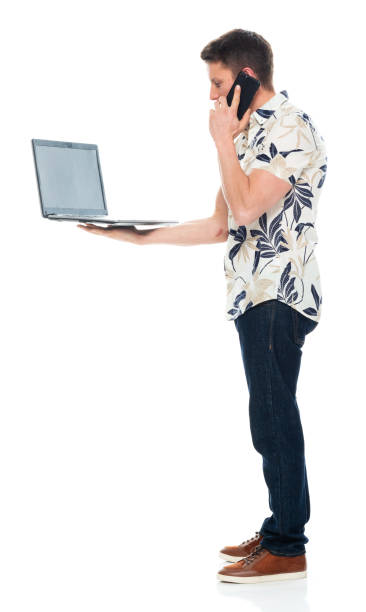 istock Caucasian young male standing in front of white background wearing jeans and using computer 1226663894