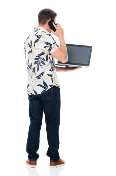 istock Caucasian young male standing in front of white background wearing jeans and using computer 1226663906