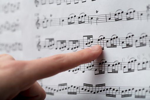 Female finger following the notes on a classical music score in a close up full frame view