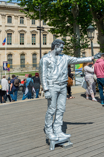 Paris, France - May 23, 2014: Young street artist, who likens herself to make-up artist sculpture with make-up, attracts the attention of tourists.