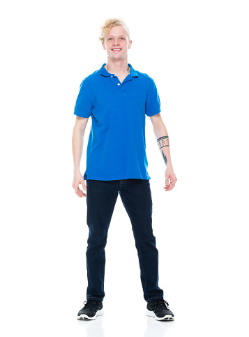 Front view of aged 20-29 years old with blond hair caucasian male standing in front of white background wearing jeans who is laughing with hand by side