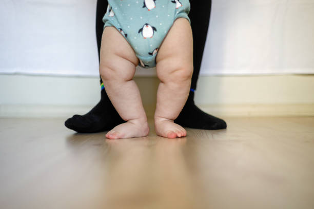 istock Mother Helping Baby Son To Take First Steps At Home 1226666164