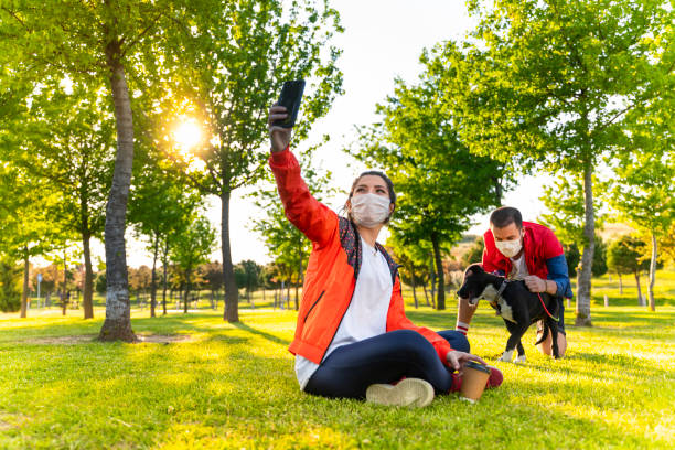 istock Cheerful university student taking selfie with friends sitting on grass 1226666207