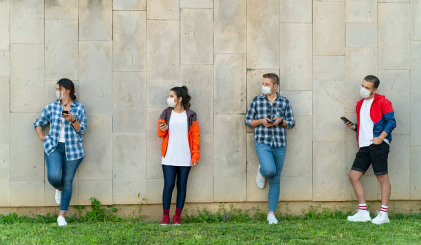 istock Teenagers texting mobile phone messages leaning on urban wall 1226667095