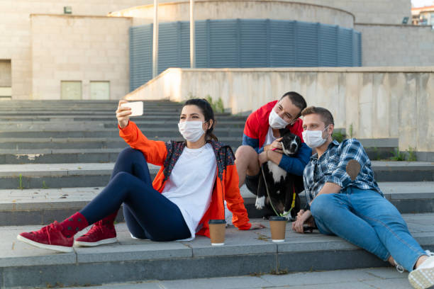 istock Cheerful university student taking selfie with friends sitting on steps 1226667939