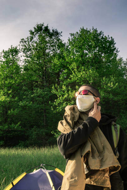 istock Young Adult Man Removing Protective Mask When Arriving on Campsite 1226669725