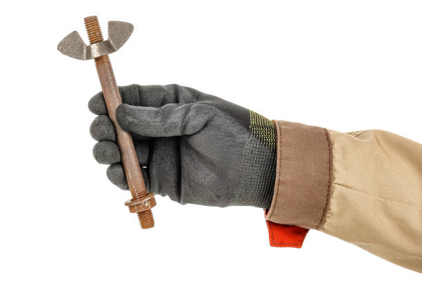 istock Large old rusty bolt in worker hand in black protective glove and brown uniform isolated on white background 1226670970