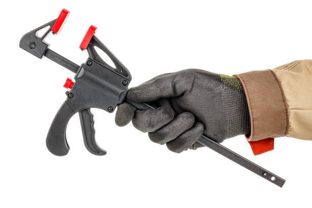 istock Quick release clamp in worker hand in black protective glove and brown uniform isolated on white background 1226670976