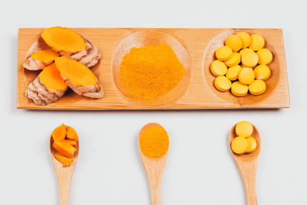 turmeric in different conditions: dry root, tablets, powder and cut plant. - flatware silverware in a row eating utensil imagens e fotografias de stock
