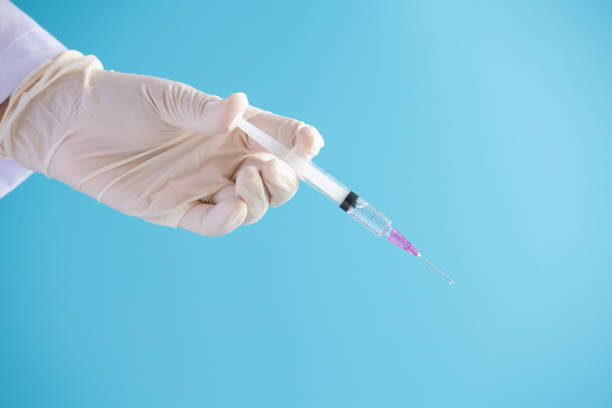 istock Doctor hand hold Syringe vaccine for corona virus on isolate blue background concept for Coronavirus pandemic disease, COVID-19 virus from epidemic outbreak to wide concept for social scientist vaccine 1226673986