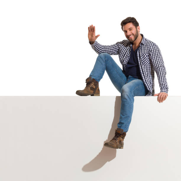istock Handsome Man Is Sitting Relaxed On A Top With Hand Raised 1226674007
