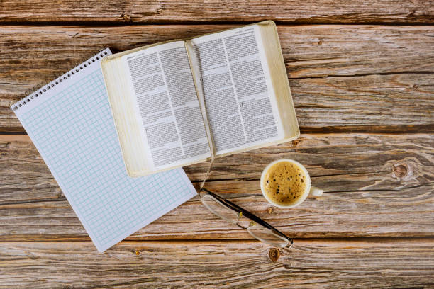 istock Personal Holy Bible study with a cup of coffee on a table top with eyeglasses, spiral notepad 1226676986