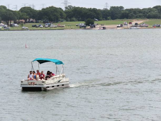 Two girls in bikinis jump off a boat into a lake