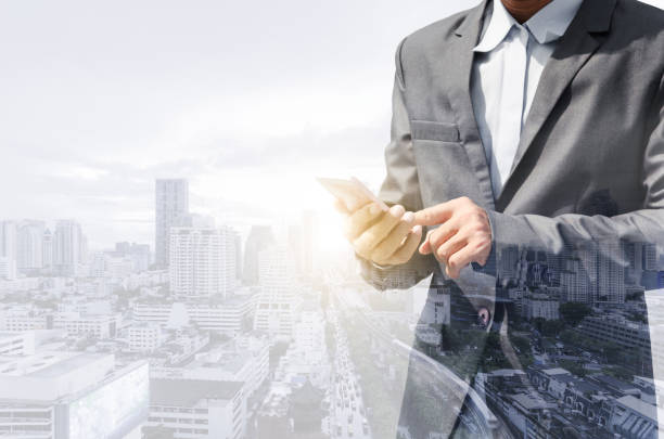istock double exposure city and businessman using smartphone searching with internet online networking. device mock up mobile phone texting communication connecting. 1226684254