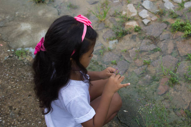 Small baby girl playing outdoors in public park.
