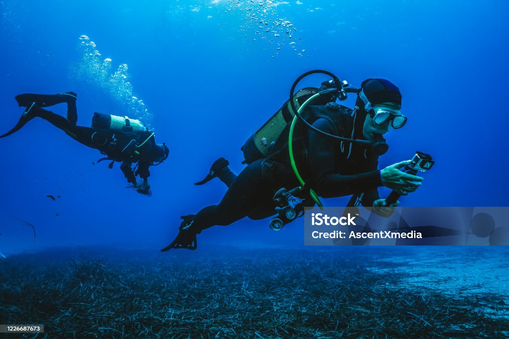 Scuba divers explore underwater reefs He films it on his underwater camera Underwater Diving Stock Photo