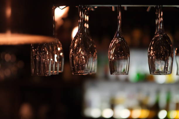 istock close up drinking glasses hanging upside down in the bar at night. 1226688469