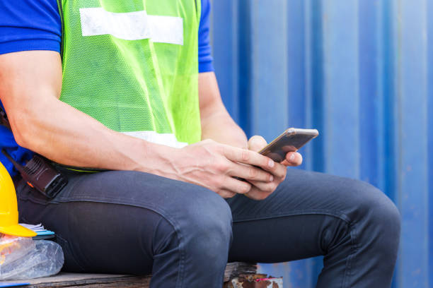 istock Engineer man uses mobile phone, Industrial worker using mobile smartphone in industry containers cargo 1226691421