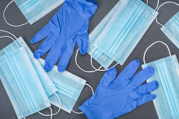 istock Protective medical masks and rubber gloves on gray background. 1226692305