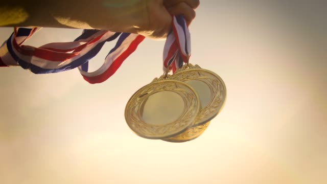 Hand holding gold medal up