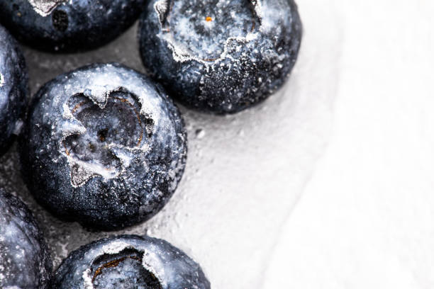 Frozen blueberries close up view on ice.