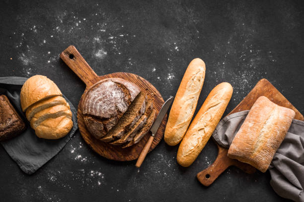 Fresh Bread Fresh Bread on black background, top view, copy space. Homemade fresh baked various loafs of wheat and rye bread flat lay. artisanal food and drink photos stock pictures, royalty-free photos & images