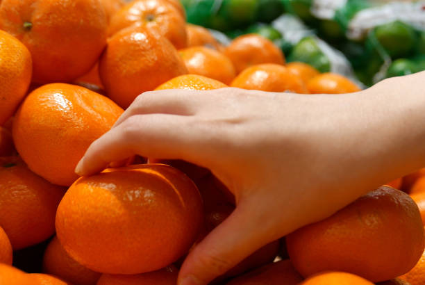 istock Motion of woman's hand picking mandarin inside superstore 1226707298