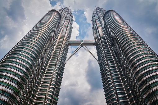 View from below up to the iconic Petronas Twin Towers in Downtown Kuala Lumpur. Ultra Wide Angle Architecture Shot. Kuala Lumpur, Malaysia, Asia.