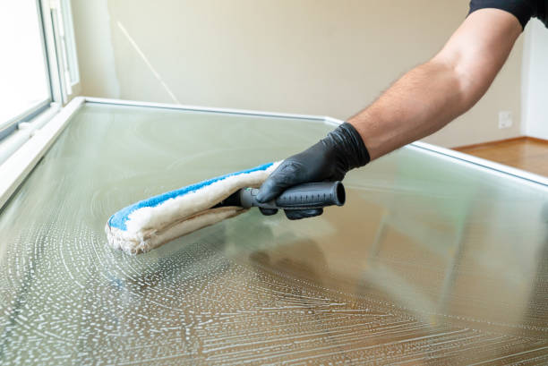 istock professional cleaner using a washer sleeve to soap and clean a large fold-down window 1226716809