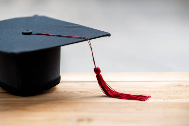 istock closeup, black graduated hat and red tassels placed on wood and copyspace 1226717557