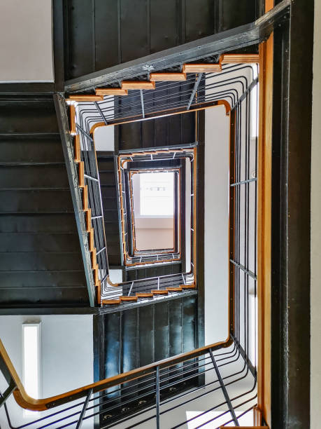 istock Lookup to spiral rectangle metal staircase with window on top 1226720012