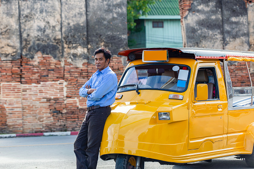 Portrait senior man driver Tuk Tuk touring at Ayutthaya Historical Park, Ayutthaya, Thailand