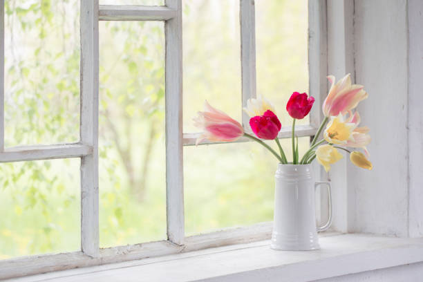small wooden window with flower pot on a traditional old farmhouse in the Austrian alps