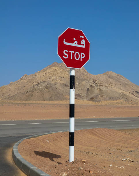 znak stop, w języku arabskim i angielskim skrypt na pustyni - sign stop sign arabic script oman zdjęcia i obrazy z banku zdjęć
