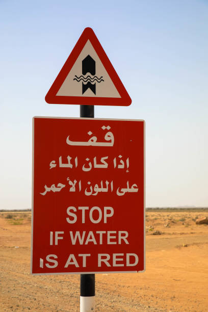 znak drogowy zatrzymaj się, jeśli woda na drodze. nie jedź, jeśli woda jest na czerwonym znaku umieszczonym na drodze. ostrzeżenie przed powodziami w omanie. - sign stop sign arabic script oman zdjęcia i obrazy z banku zdjęć
