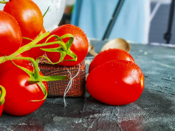 istock Small water drops on small cherry tomatoes on green branch 1226722652