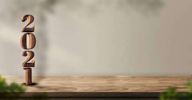istock 2021 happy new year wood number (3d rendering) on wood table background with sunlight window create leaf shadow on wall with blur green plant foreground.panoramic banner mockup for display product 1226723810
