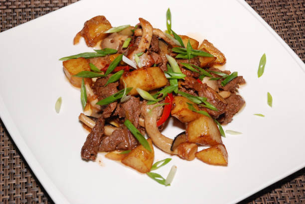 istock fried beef with green onion, mushrooms and potatoes on the white plate. selective focus 1226727255