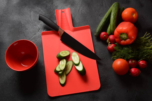 istock Fresh cucumbers and knife on a cutting board. Preparing, cooking food concept 1226728700